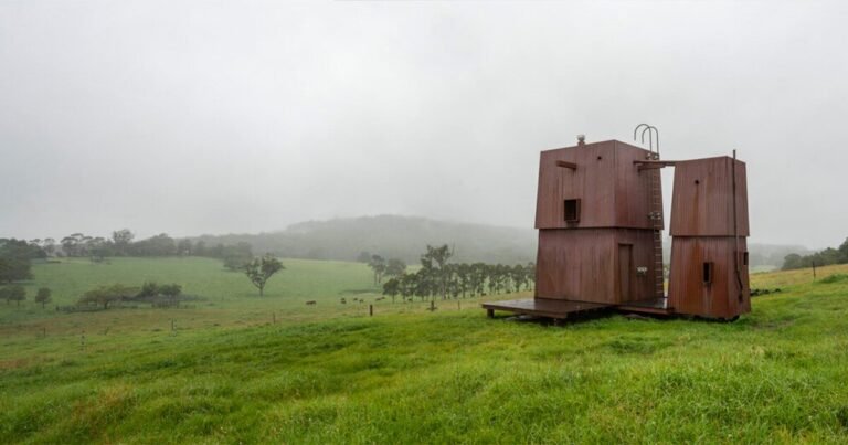 casey brown units copper-clad cabin with movable awnings inside lush australian paddocks
