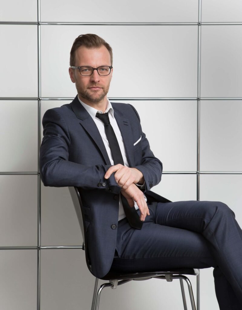 صورة شخصية لرجل جالس وذراعه اليمنى ملفوفة