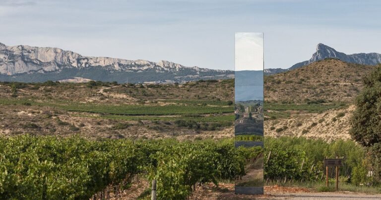 mirror-clad tower emerges as an ephemeral poetic landmark inside spanish winery
