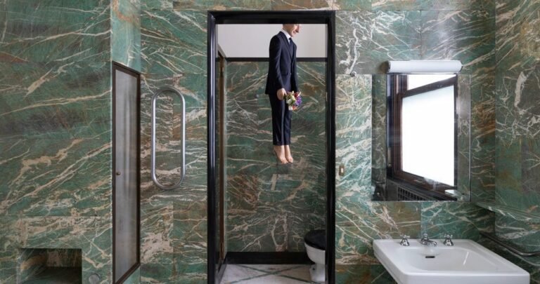 a self-portrait by maurizio cattelan hangs in the bathroom of milan’s massimo de carlo gallery