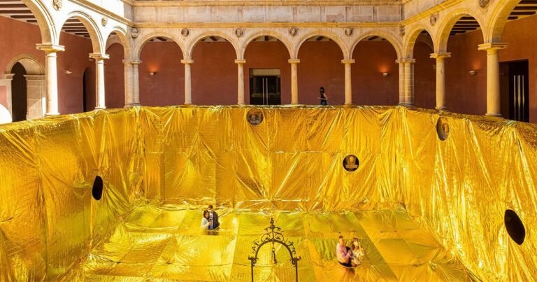 golden sheet made out of emergency blankets covers 16th-century convent patio in spain