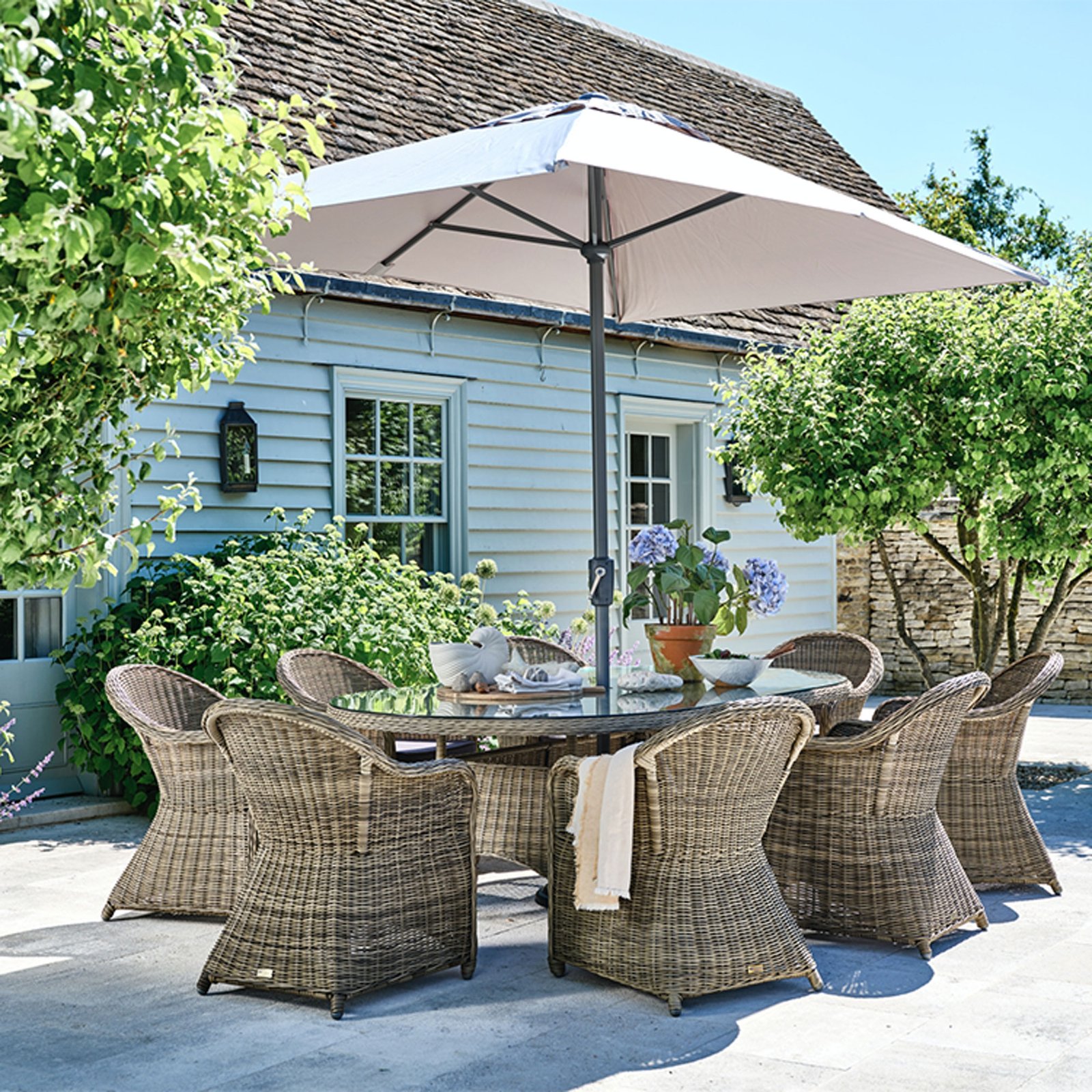 oval woven garden table and chair set with outdoor parasol