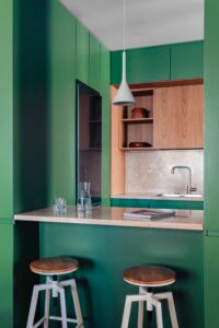 مطبخ أخضر في طاولة شقة في روما براز خزانات خضراء وخزائن خشبية