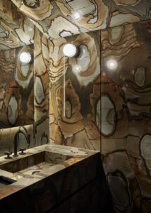 يلف الرخام الأحفوري البرازيلي غرفة مسحوق في شقة في ميلانو من تصميم Luca Cipelletti.