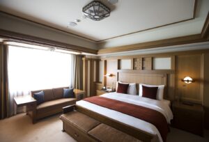 توجد أريكة وسرير في جناح فرانك لويد رايت في فندق إمبريال في طوكيو باليابان