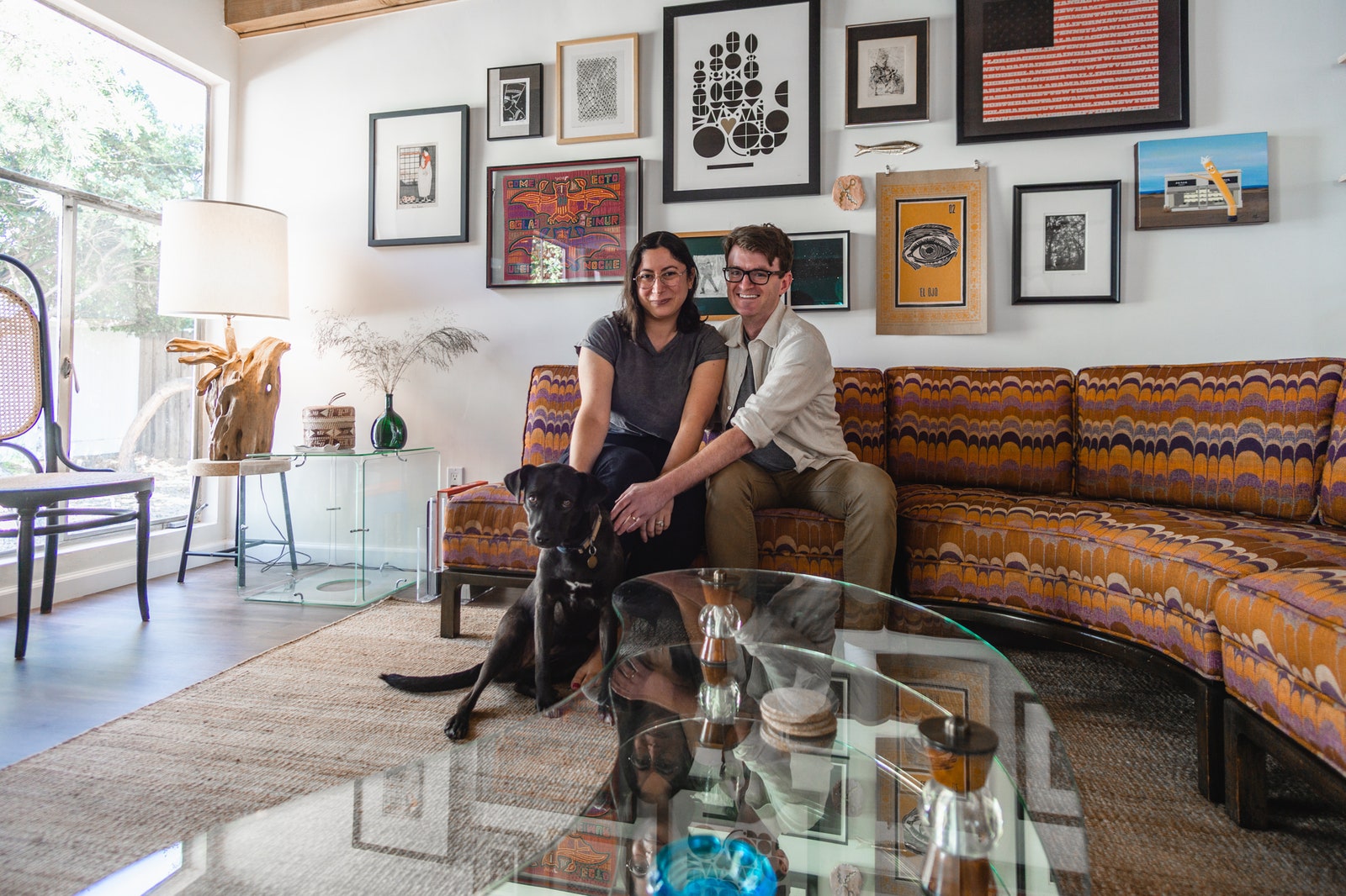 ستيفاني آدم وجروهما ديزي يبتسمان على الأريكة.  صور مايك بيترز