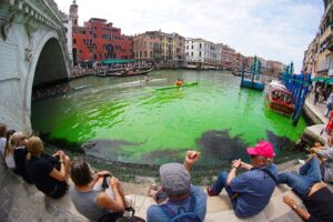 مياه خضراء ناصعة تحت جسر ريالتو في القناة الكبرى في البندقية