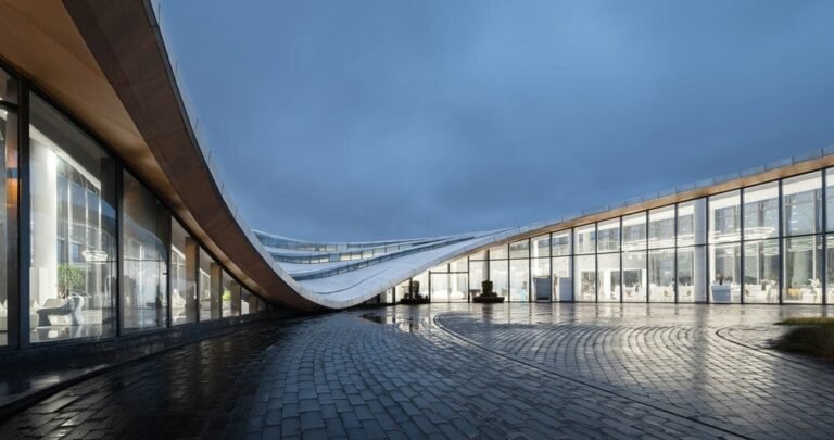MUDA-architects’ coastal haikou visitor center enclosed by a fluid, cascading rooftop