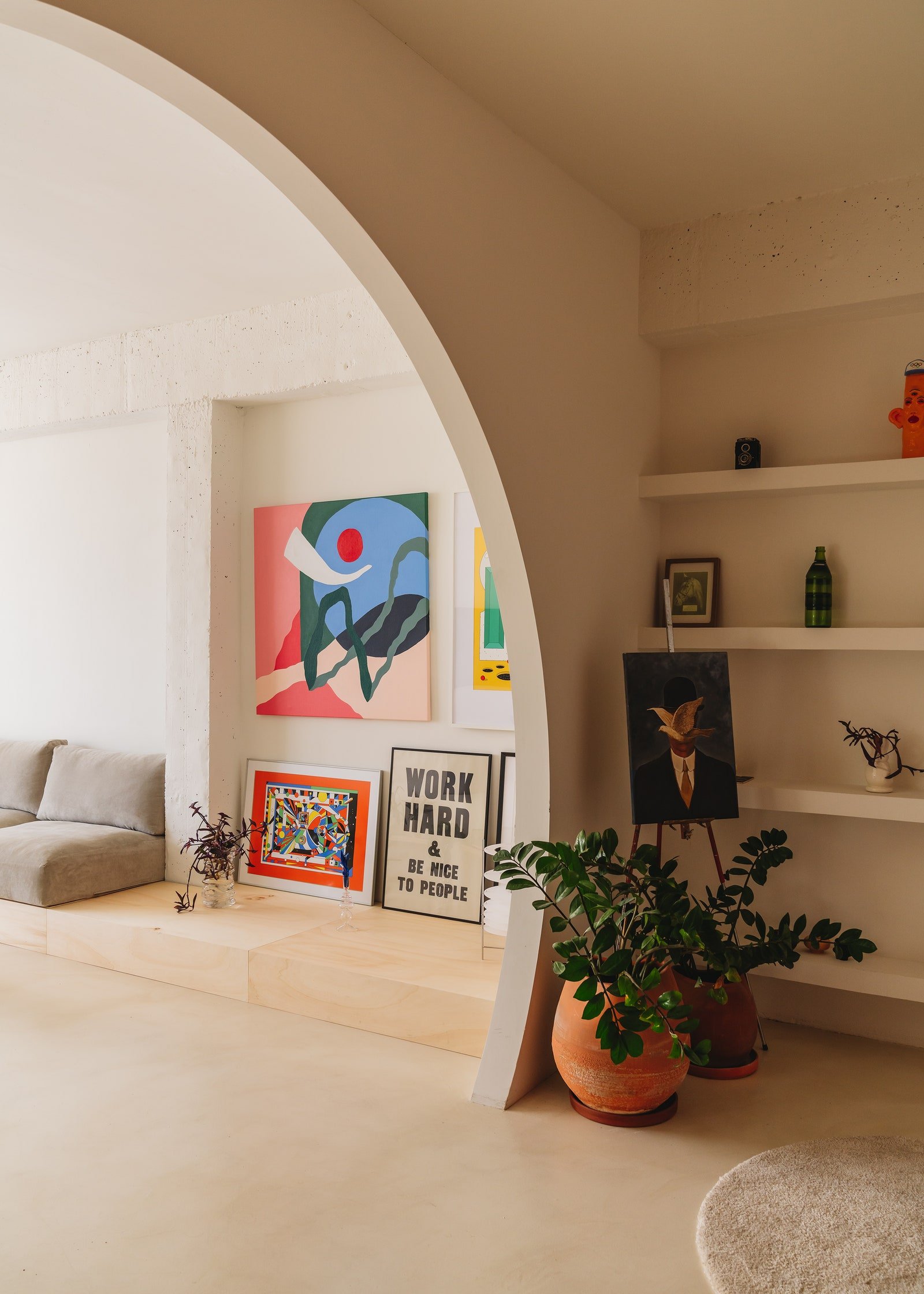 large arch doorway with shelves to the right and living space to the left