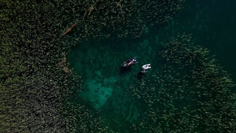 aerial photo of diver exploring submerged ancient village of Lin