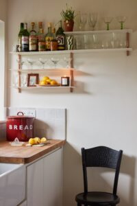 kitchen with slim shelves containing glasses and bottles