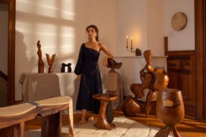 Kim Mupangilaï at home in Brooklyn with some of her new furniture pieces and vintage carvedwood sculptures.