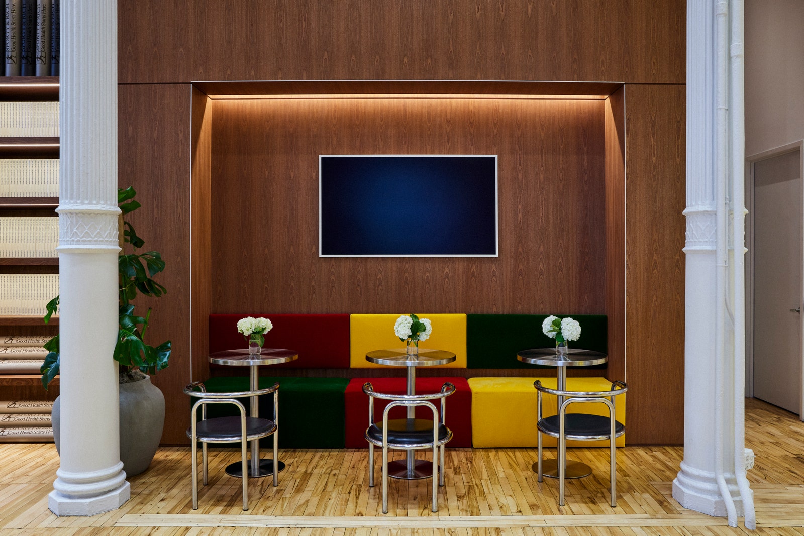 Red yellow and green colorblocked sofa beneath a screen in the Sporty  Rich store