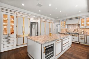 Zoe Saldanas kitchen with white cabinetry and gold accents large central kitchen island