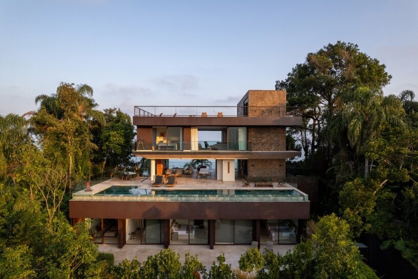 FCstudio's coastal house stacks steel, glass, & stone layers amid são paulo's rugged terrain