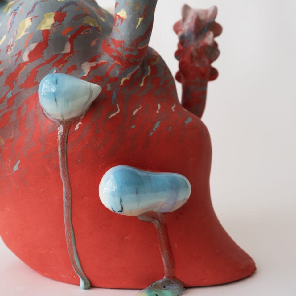 a detail of an abstract, colorful ceramic sculpture with nature-inspired elements evocative of coral or flowers