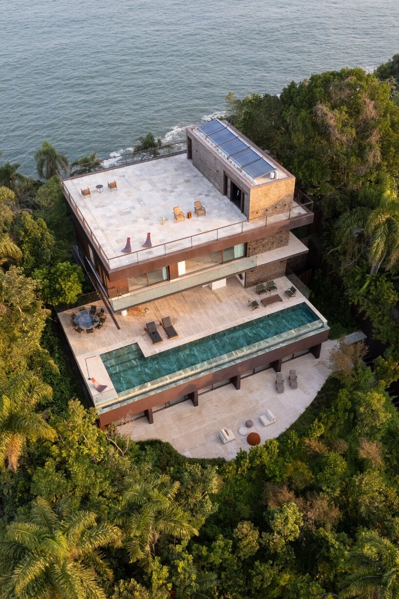 FCstudio's coastal house stacks steel, glass, & stone layers amid são paulo's rugged terrain