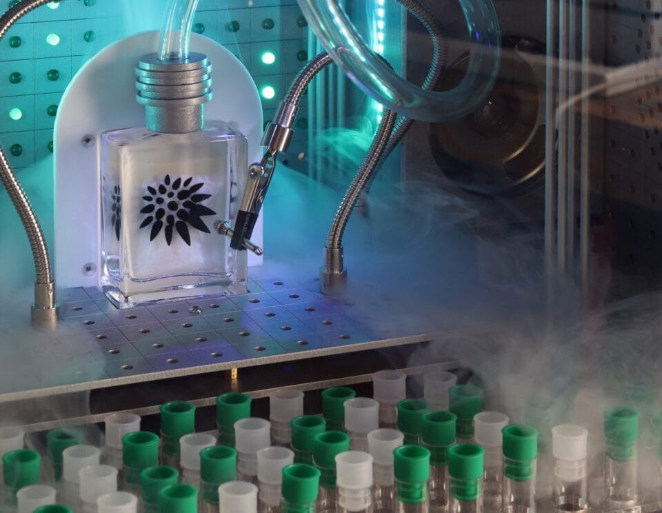 a detail of a sculpture resembling a retro computer or console in white, with a screen holding a bottle with tubing coming out of it and numerous tiny vials
