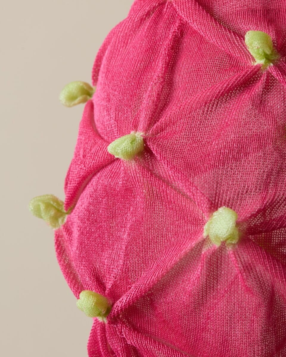 a detail of a suspended pink-and-green textile lamp shade