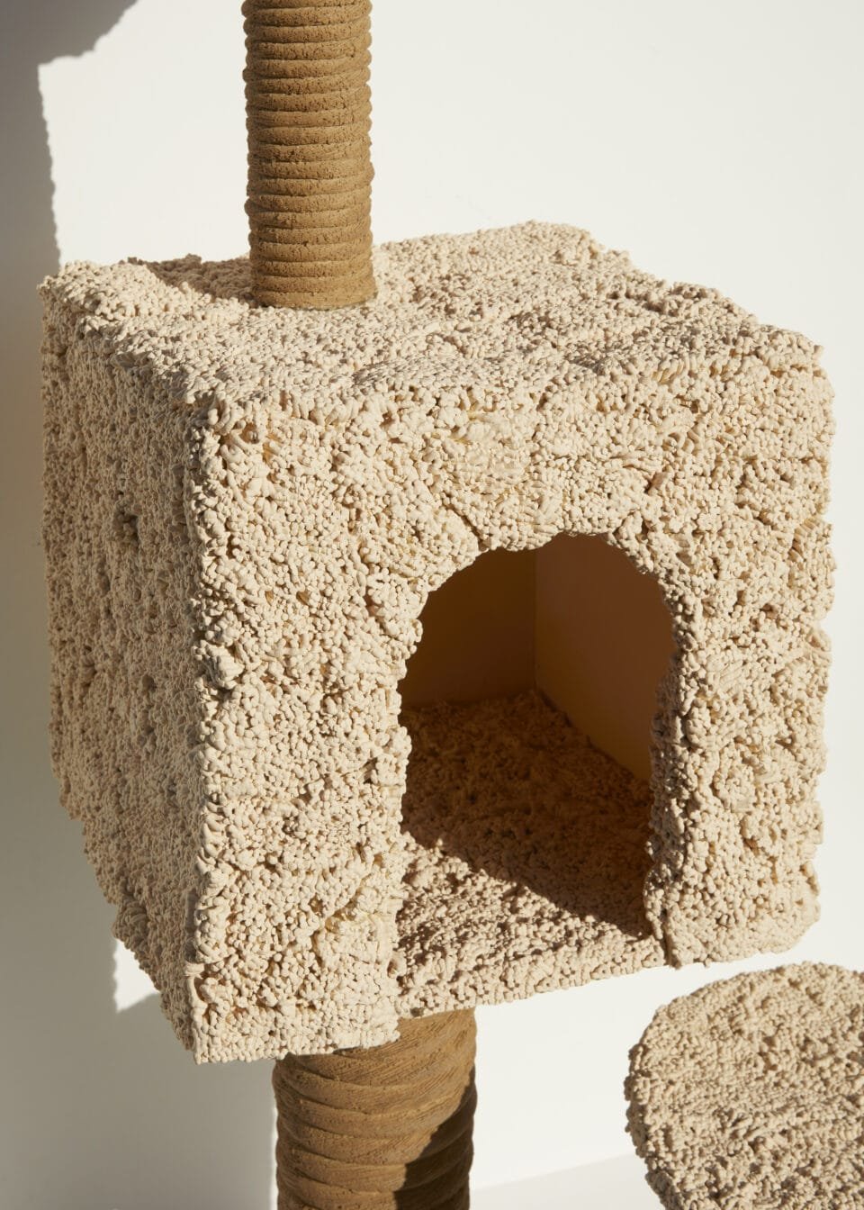 detail of a ceramic sculpture of a cat scratching tower