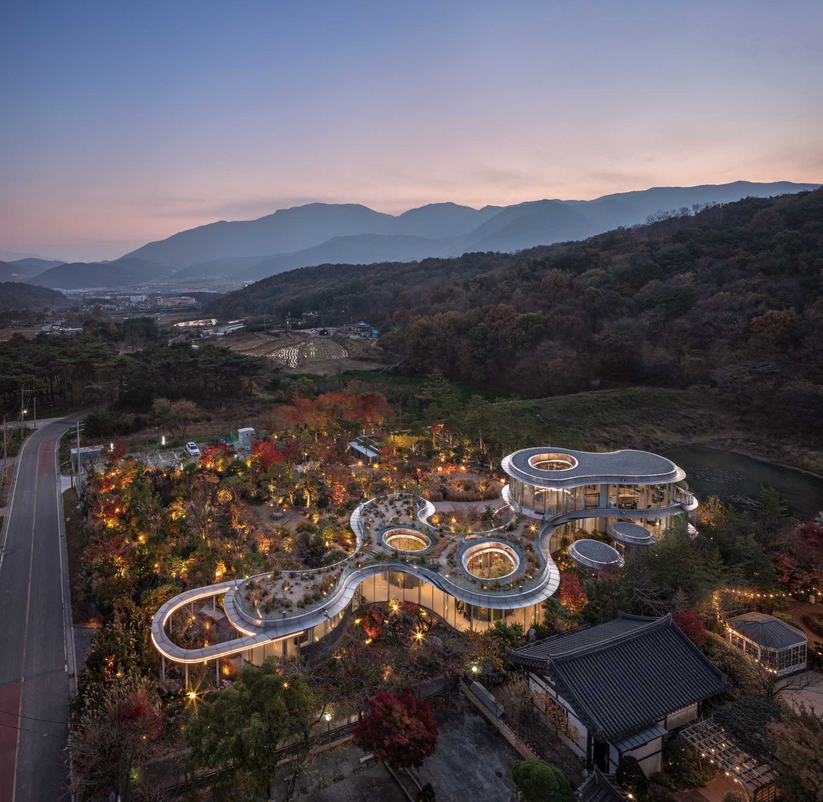 A modern cafe in South Korea, with social spaces and a green roof, was inspired by a walk in the forest.
