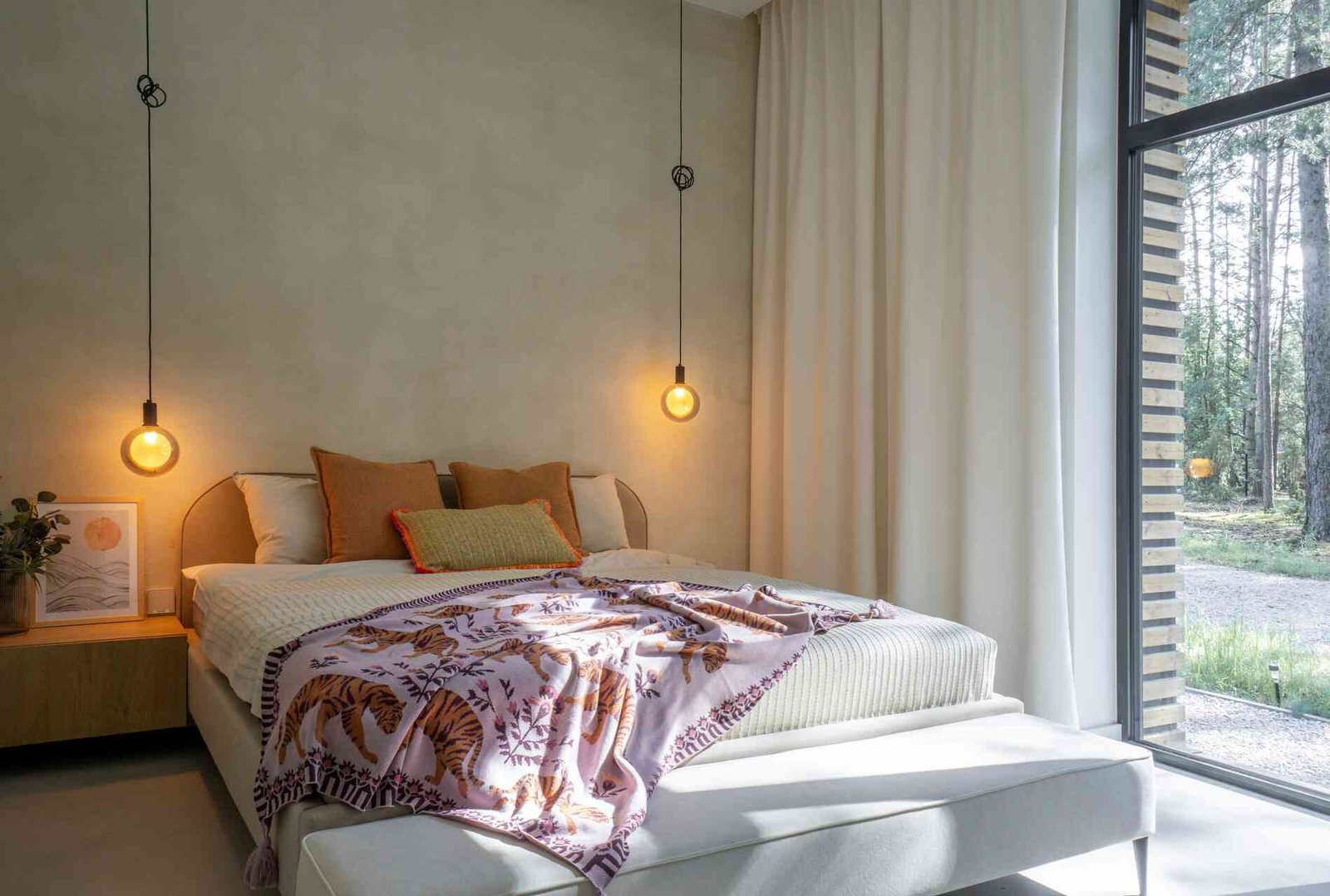 A modern bedroom with pendant lights acting as bedside lamps.