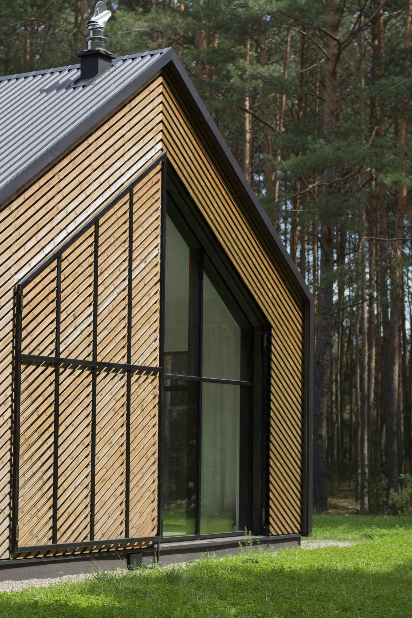 The facade of this modern home is clad in black metal and wood accents like an oversize operational screen.