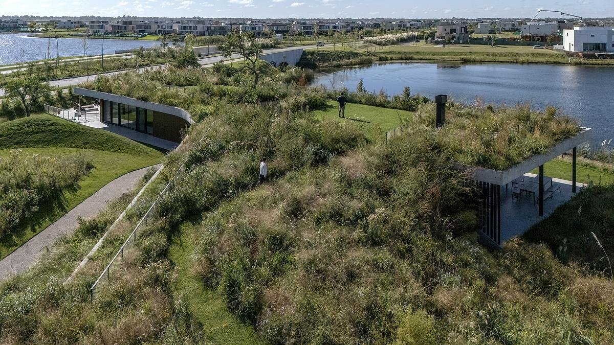 One of this project’s most striking features is its planted roof, which functions as both landscape and architecture. Instead of sitting on top of the building like an accessory, the green roof is woven into the terrain, folding down to meet the ground in a walkable ramp. This design move dissolves the boundary between natural and built, and subtly encourages people to interact with the space in ways that feel intuitive and playful.