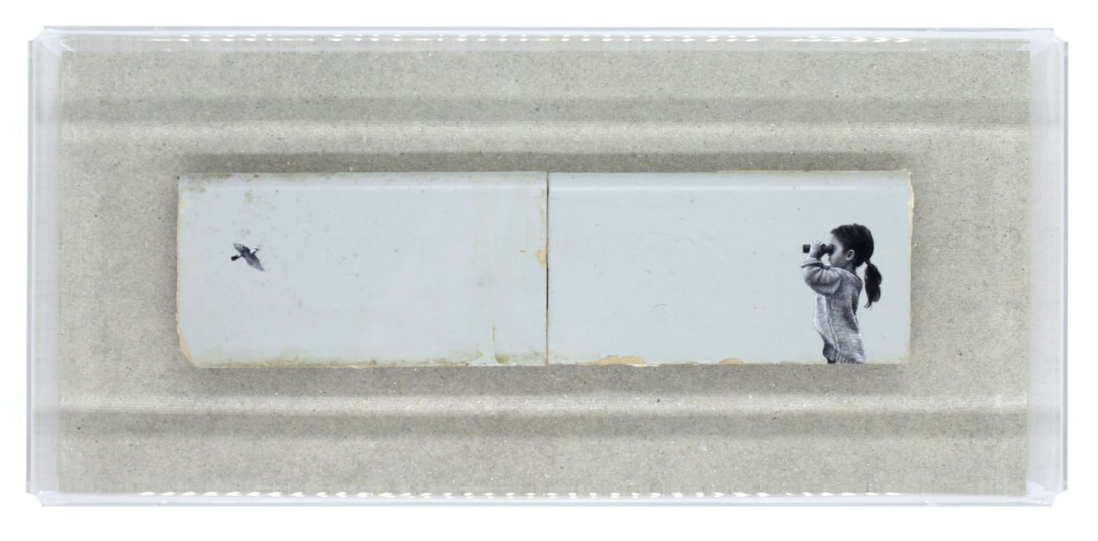 a child looks out across two bricks at a bird flying to the left