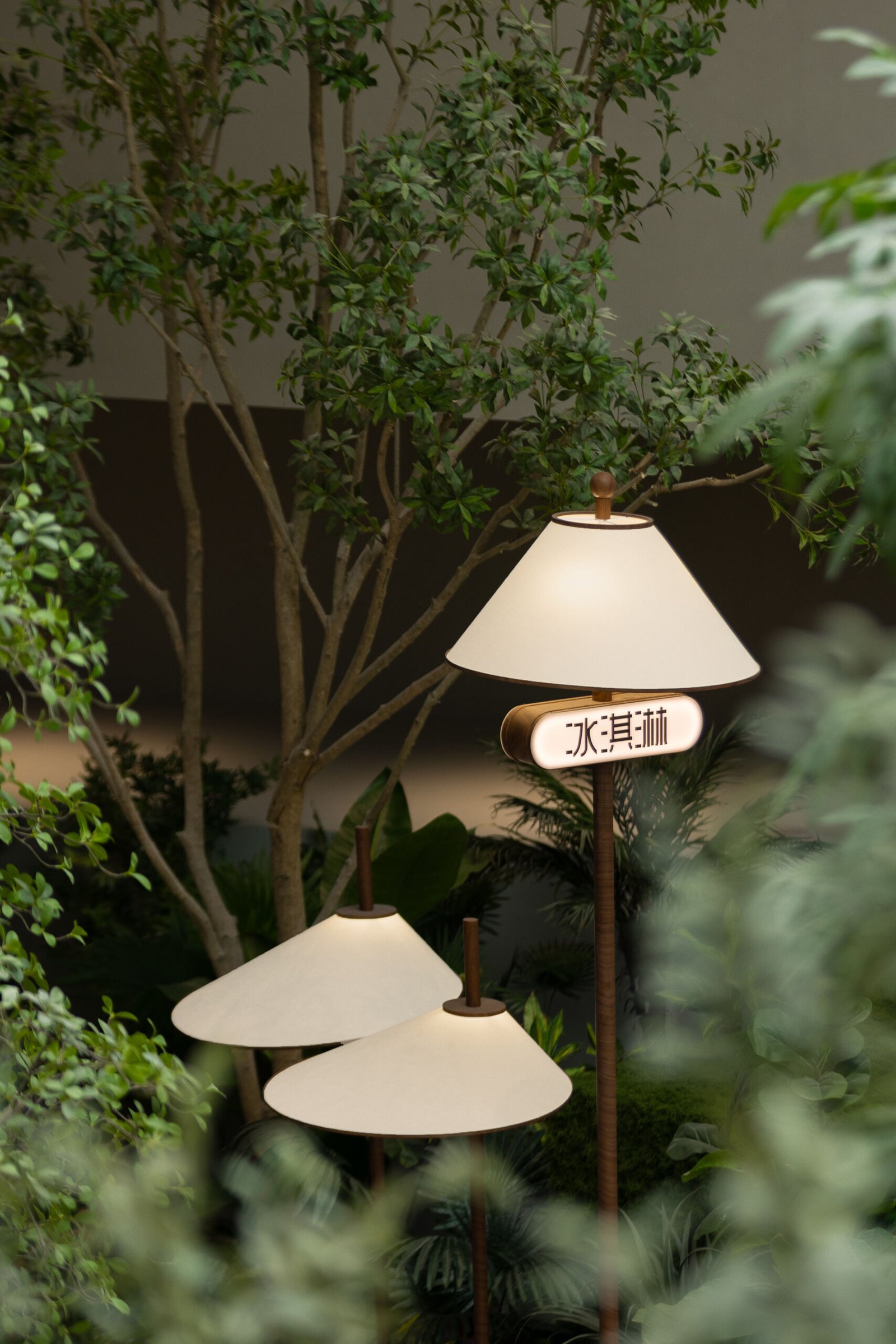 Floor lamps with wooden bases and soft fabric shades blend beautifully with the surrounding greenery. Thoughtful lighting that feels like part of the landscape, not apart from it.