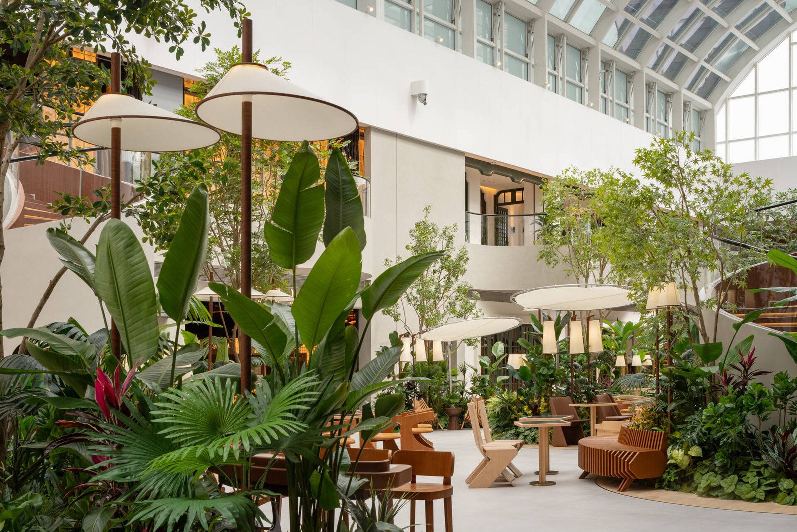 Movement through this plaza is reimagined through softly winding paths that guide visitors under filtered light and between plants. A layout that slows the pace and invites quiet exploration.