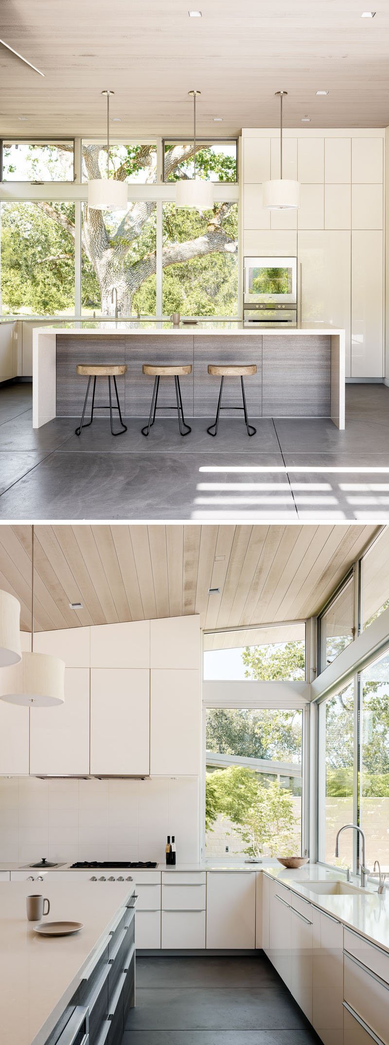 A chef’s dream kitchen with white cabinetry, a spacious island, and windows framing views of the central courtyard and oak tree.