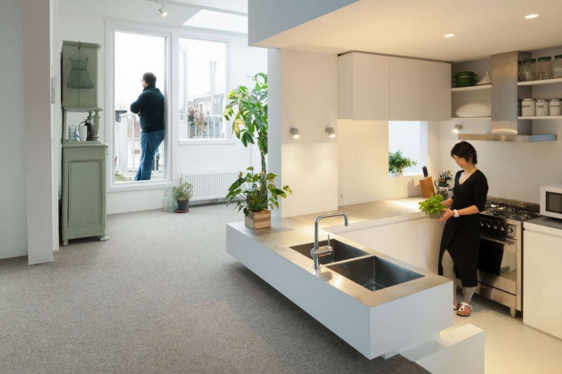 A sunken kitchen tucked into the central tower adds depth and separation without walls, maximizing both space and light in this compact family home.