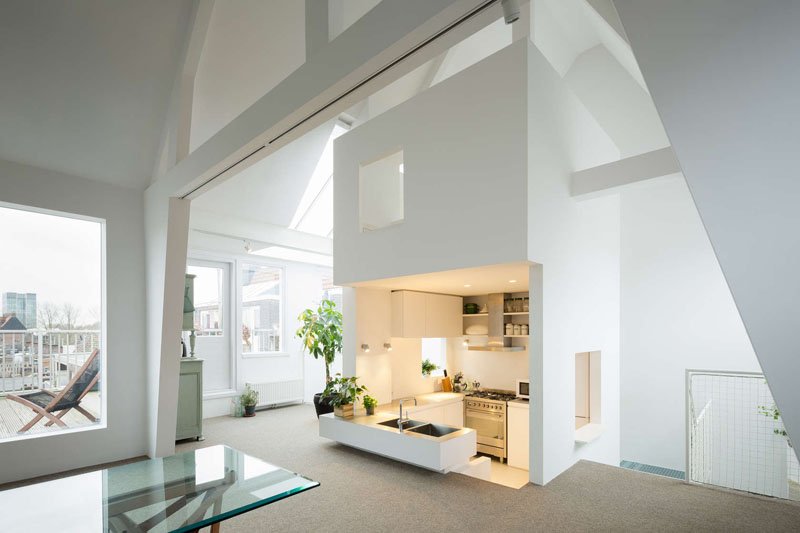 A sunken kitchen tucked into the central tower adds depth and separation without walls, maximizing both space and light in this compact family home.
