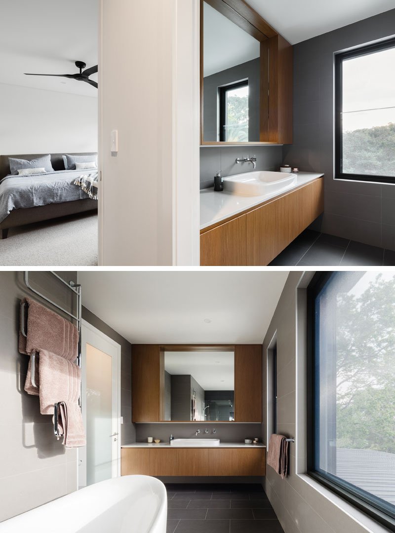 A wooden vanity and mirror surround stretch across the wall, while a floating design detail adds a sense of lightness.