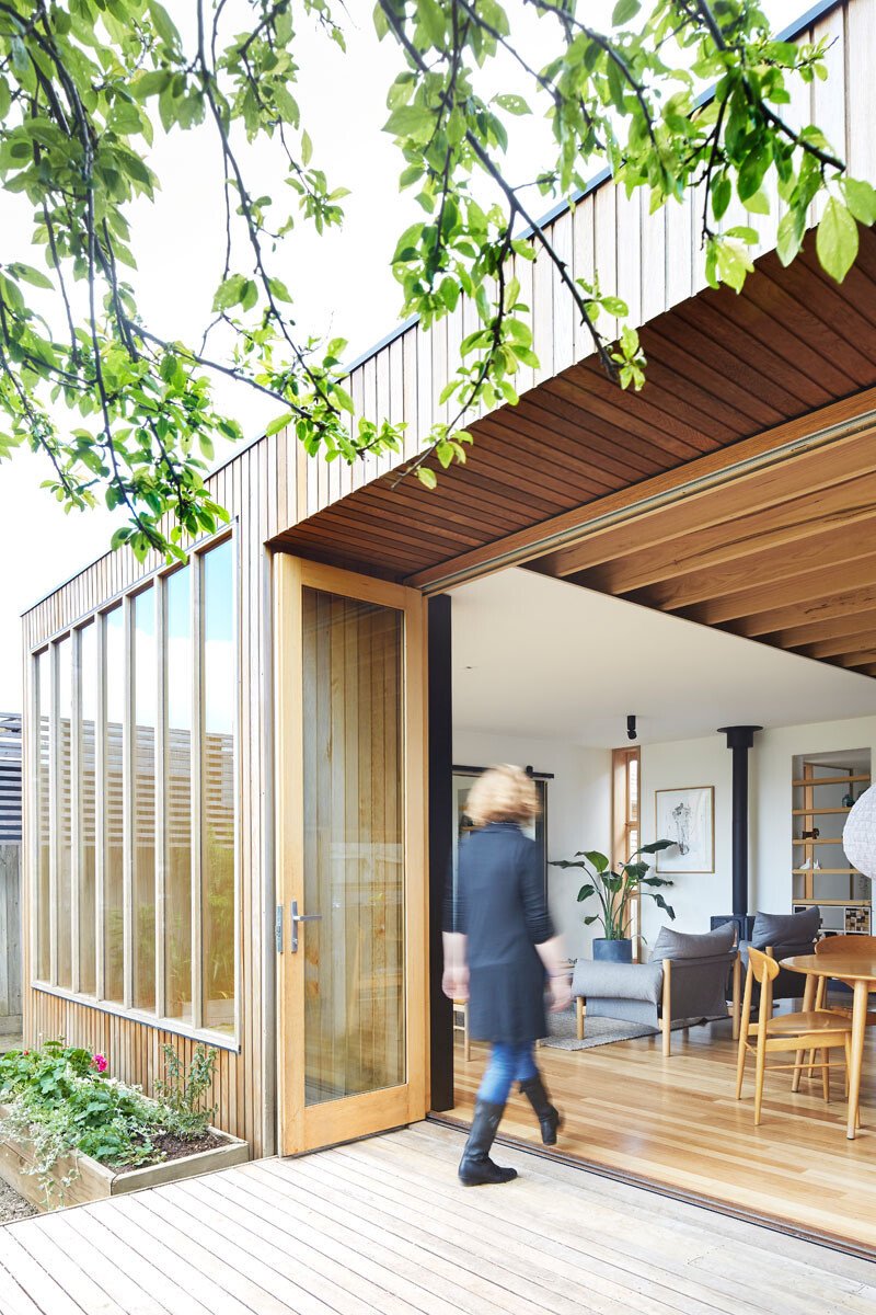 This modern house extension resembles a clean-lined timber box, crafted with Tasmanian Oak windows, exposed beams, cedar siding, and blackbutt flooring. The natural material palette grounds the modern addition while keeping it warm and inviting.