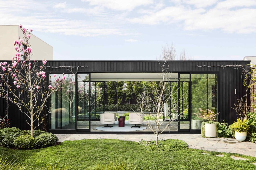This Melbourne residence combines a restored Victorian facade with dark timber and glass for a seamless modern contrast.