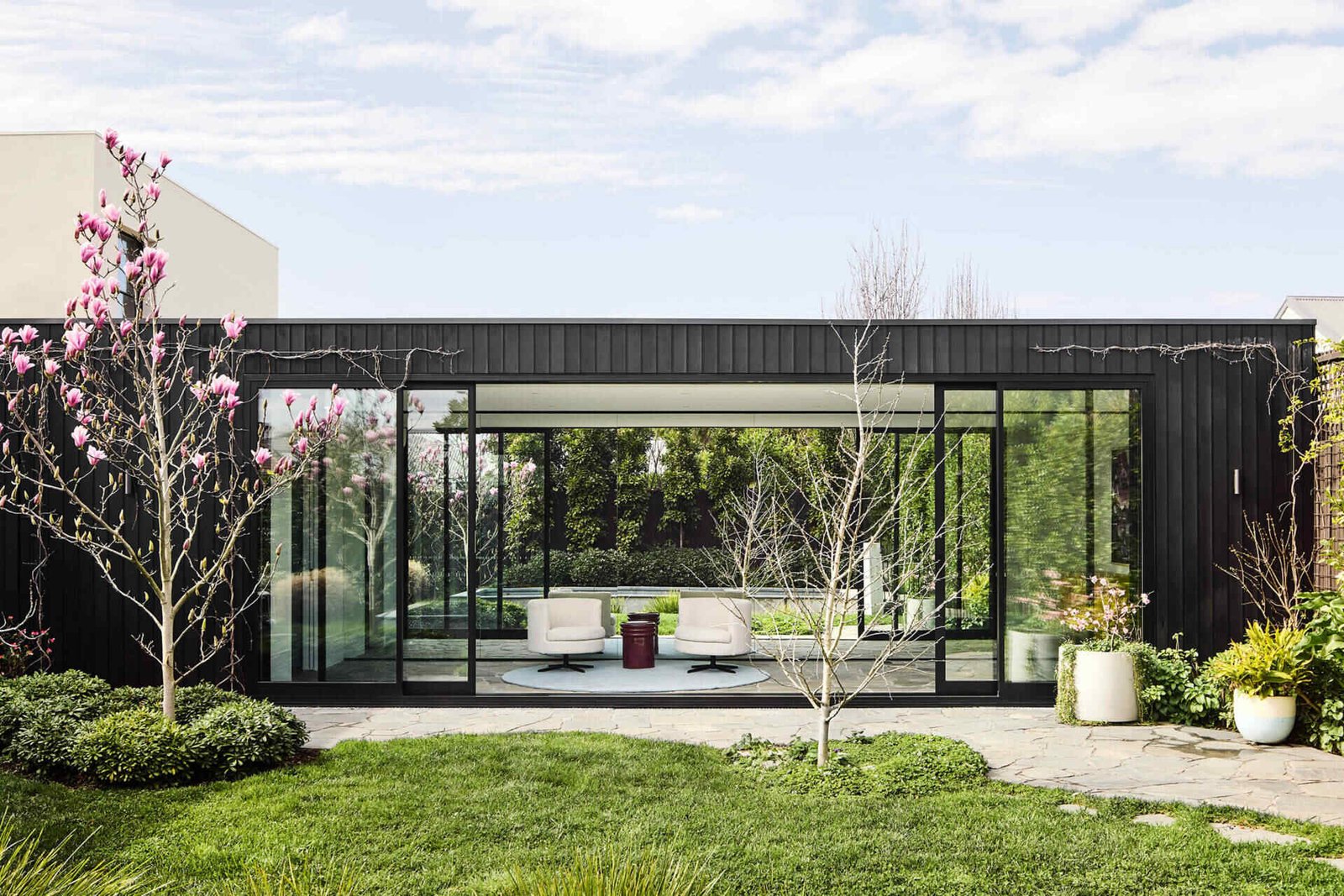This Melbourne residence combines a restored Victorian facade with dark timber and glass for a seamless modern contrast.
