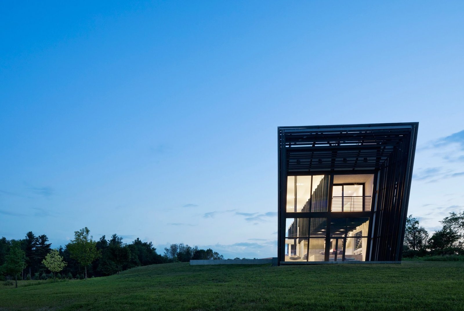 Wrapped in charred timber and set on a concrete base, this sculptural hillside home stands as a minimalist landmark in New York’s Hudson Valley.