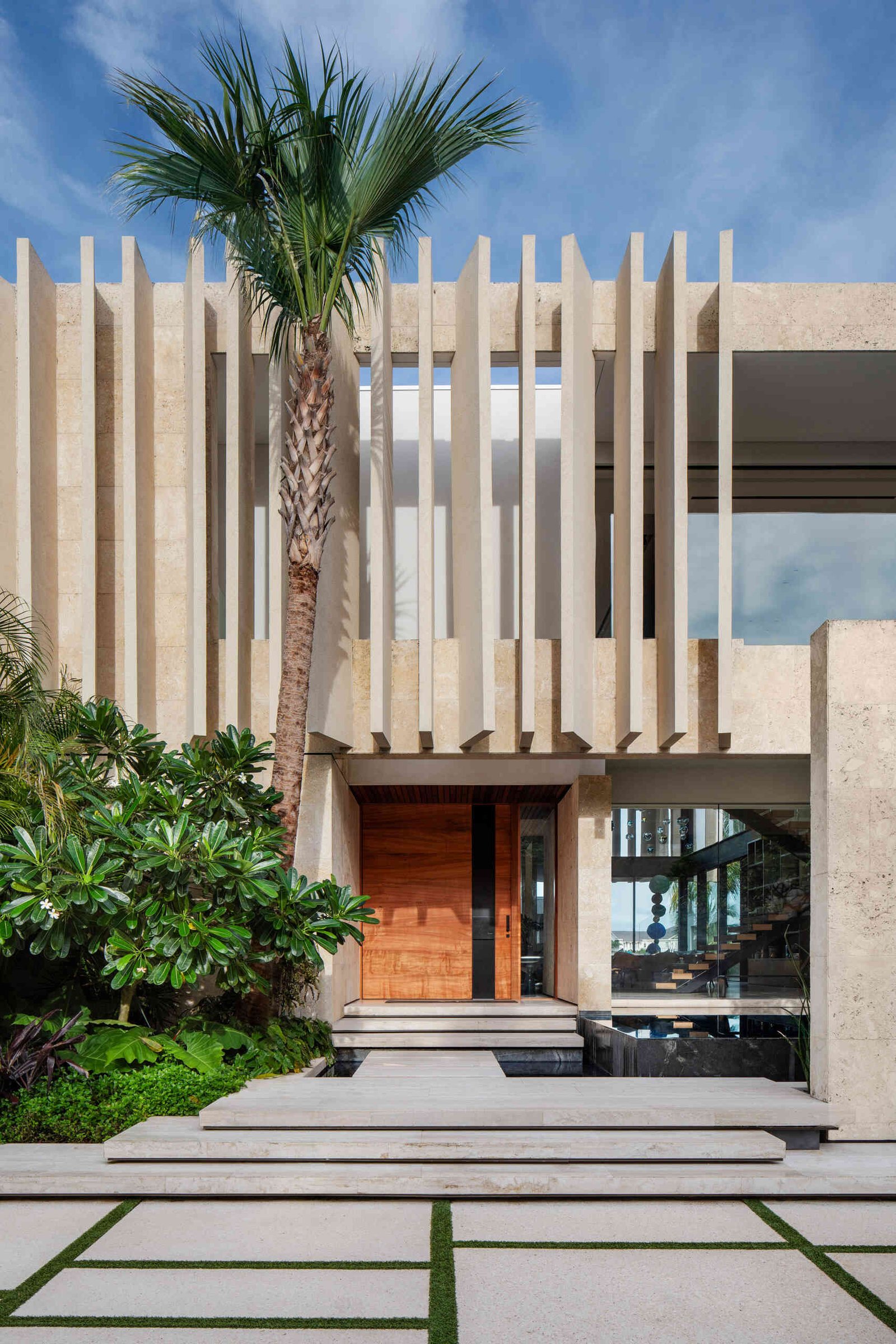 A modern island home shaped by coral stone fins and generous glazing that opens to the landscape.