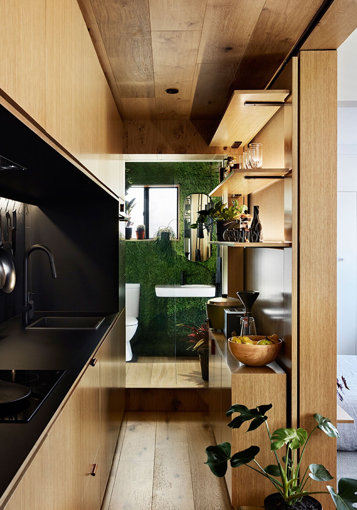 An internal window with switchable privacy film brings borrowed light from the bathroom into the kitchen.
