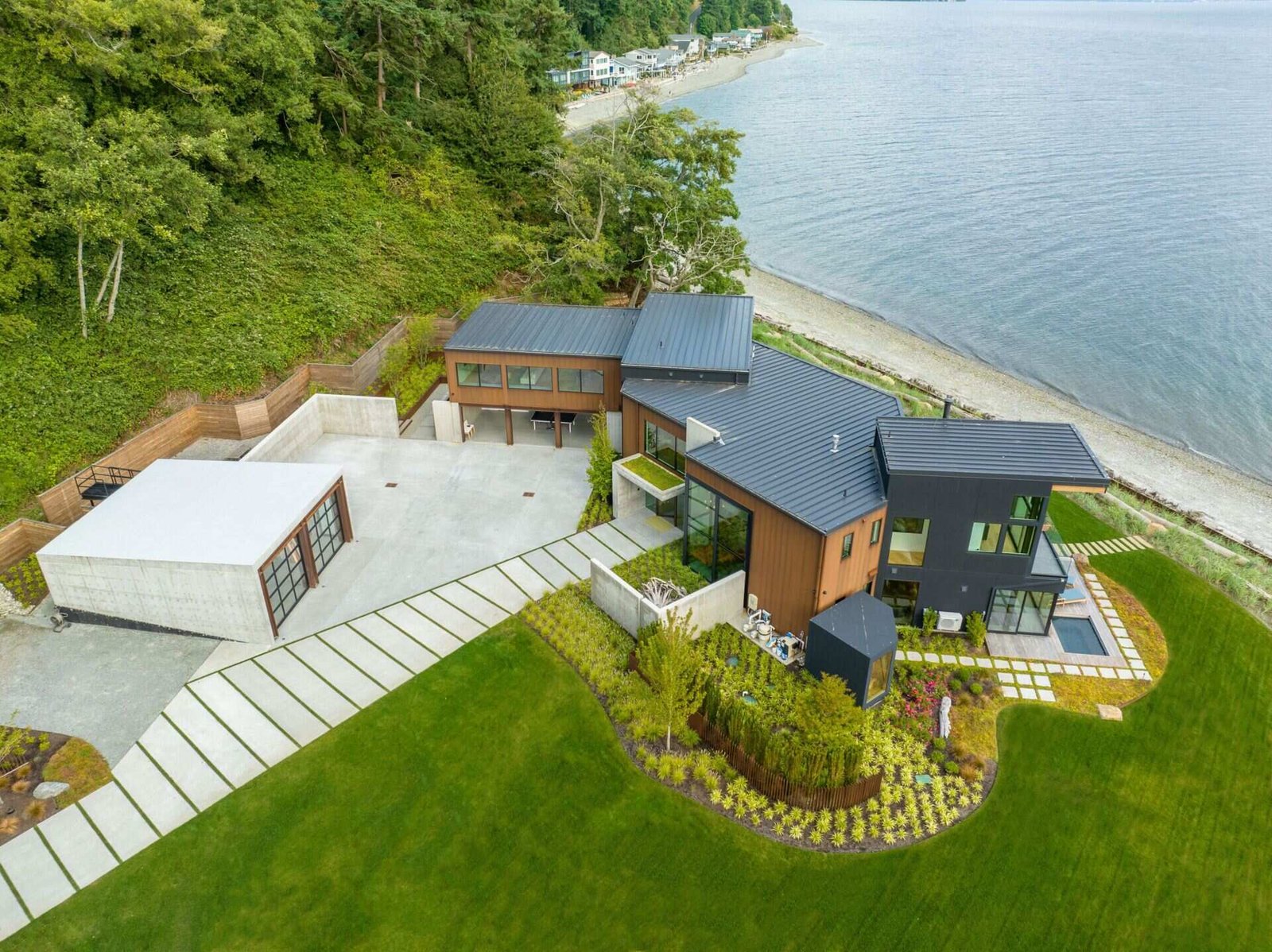 A steep hillside behind the home shaped how access and structure were planned. The driveway and garage zones are engineered as protective elements rather than simple arrival points.