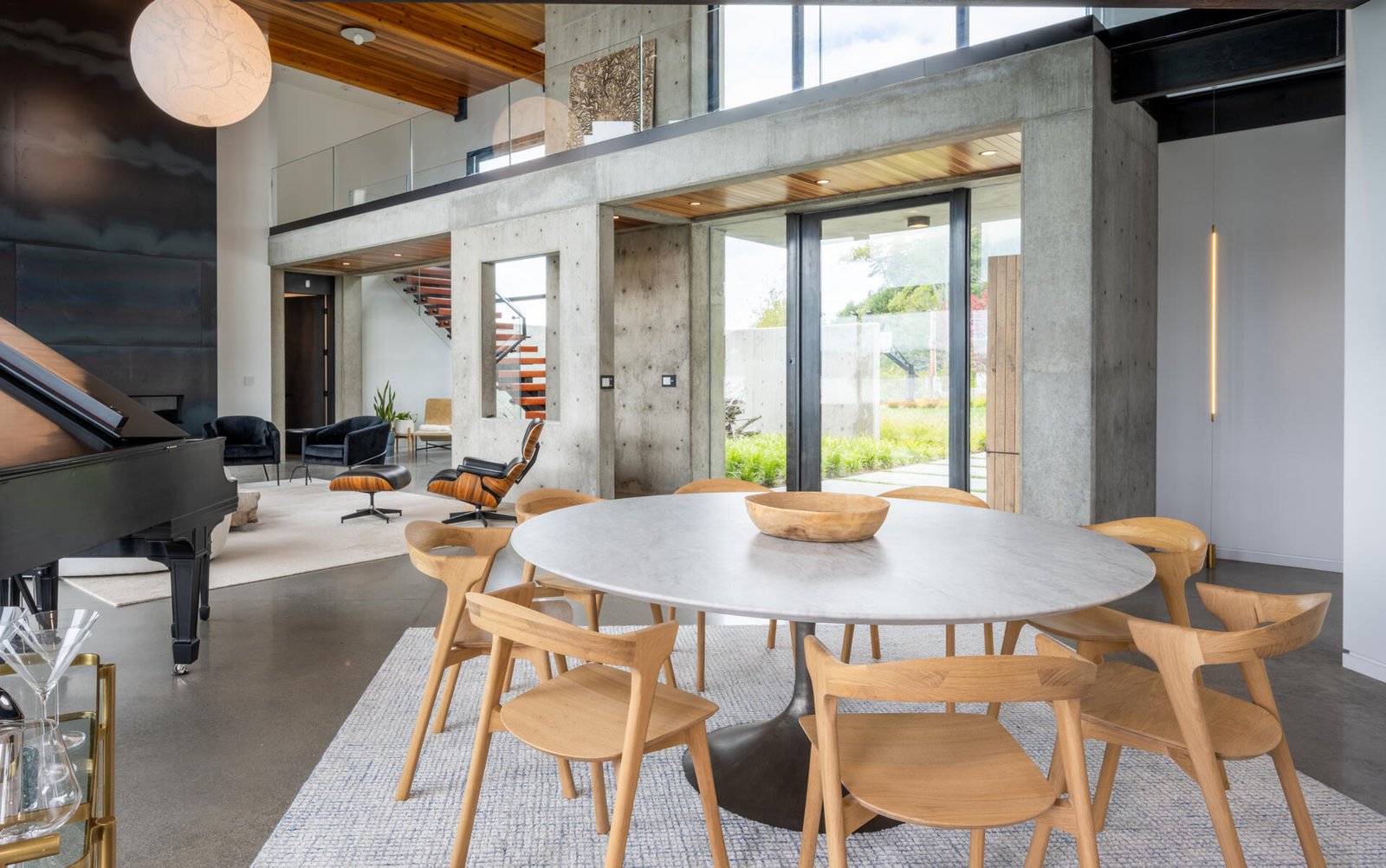 The dining area, with its round table, is integrated into the open great room between the living room and the kitchen.
