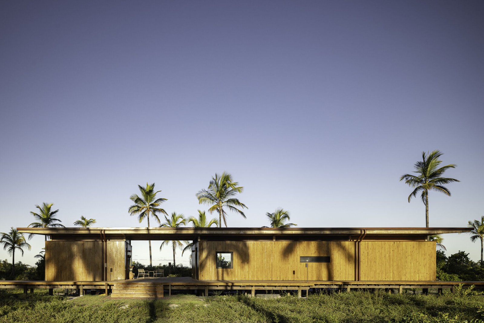 A modular home set between the river and the sea, designed for calm tropical living. Warm wood interiors, large glass openings, and open patios create a seamless flow between forest, coast, and indoor comfort.