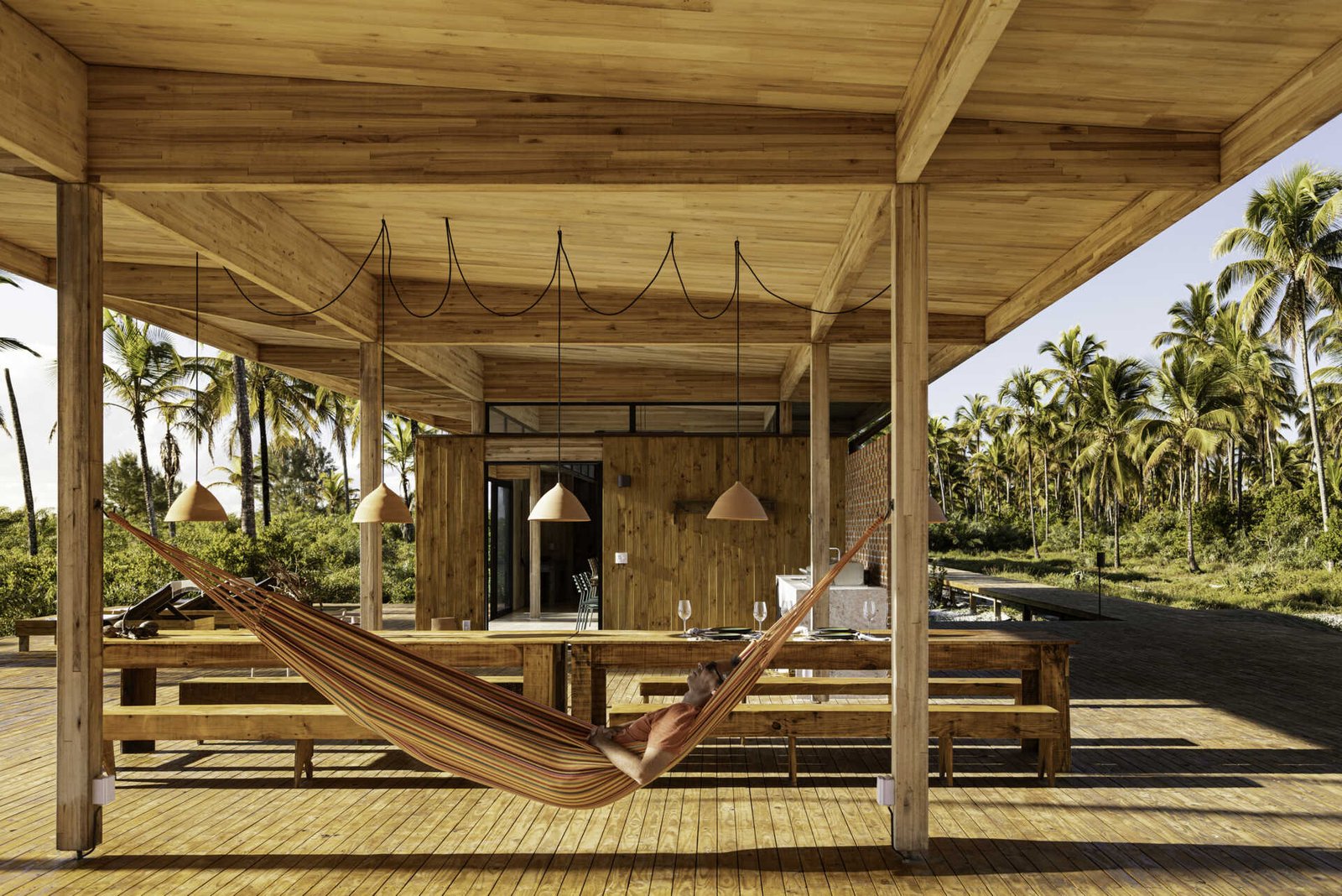A modular home set between the river and the sea, designed for calm tropical living. Warm wood interiors, large glass openings, and open patios create a seamless flow between forest, coast, and indoor comfort.