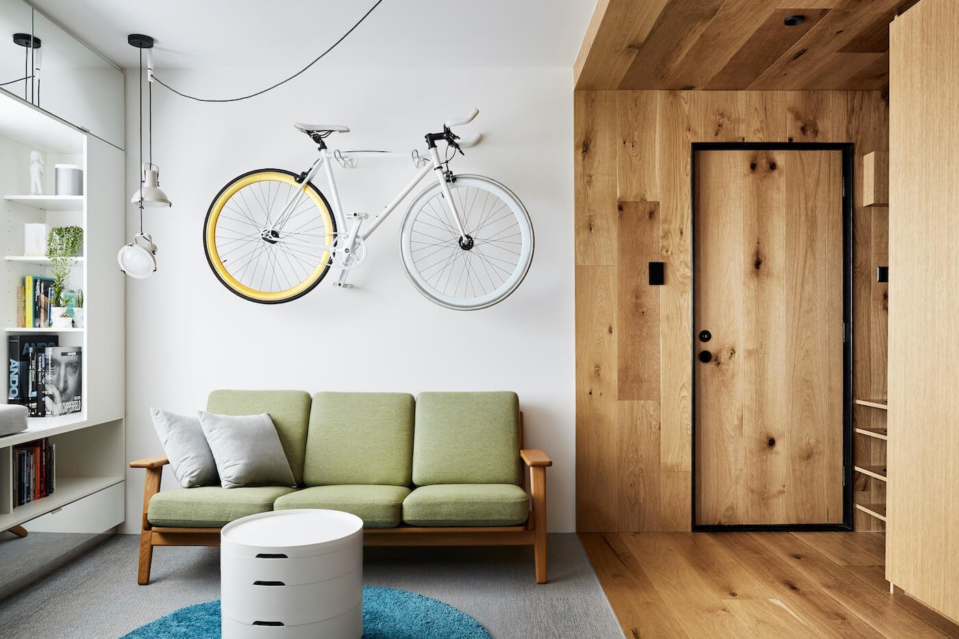 A built-in window seat and soft woven flooring add warmth and storage to the living room of this cleverly designed small apartment.