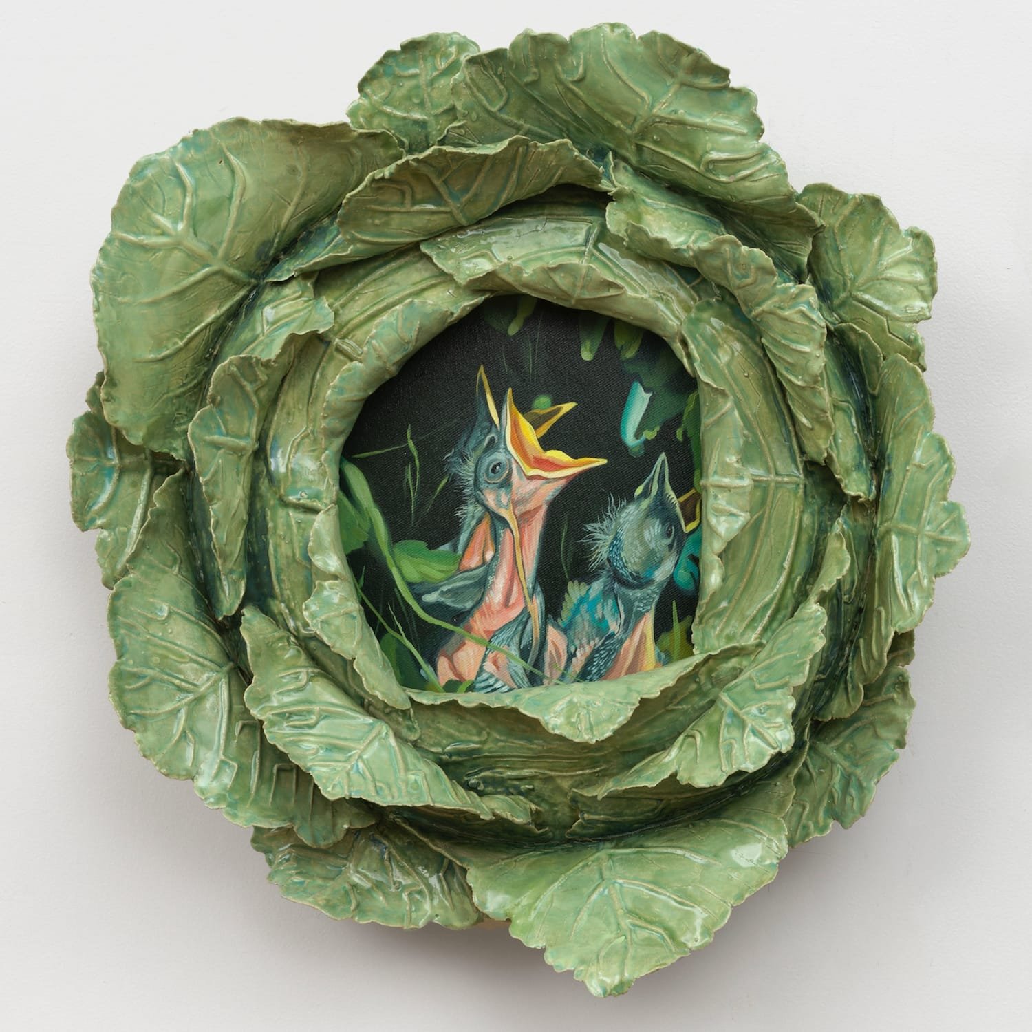 a ceramic cabbage sculpture by Stephanie Temma Heir with a painting of a hungry baby bird at the center