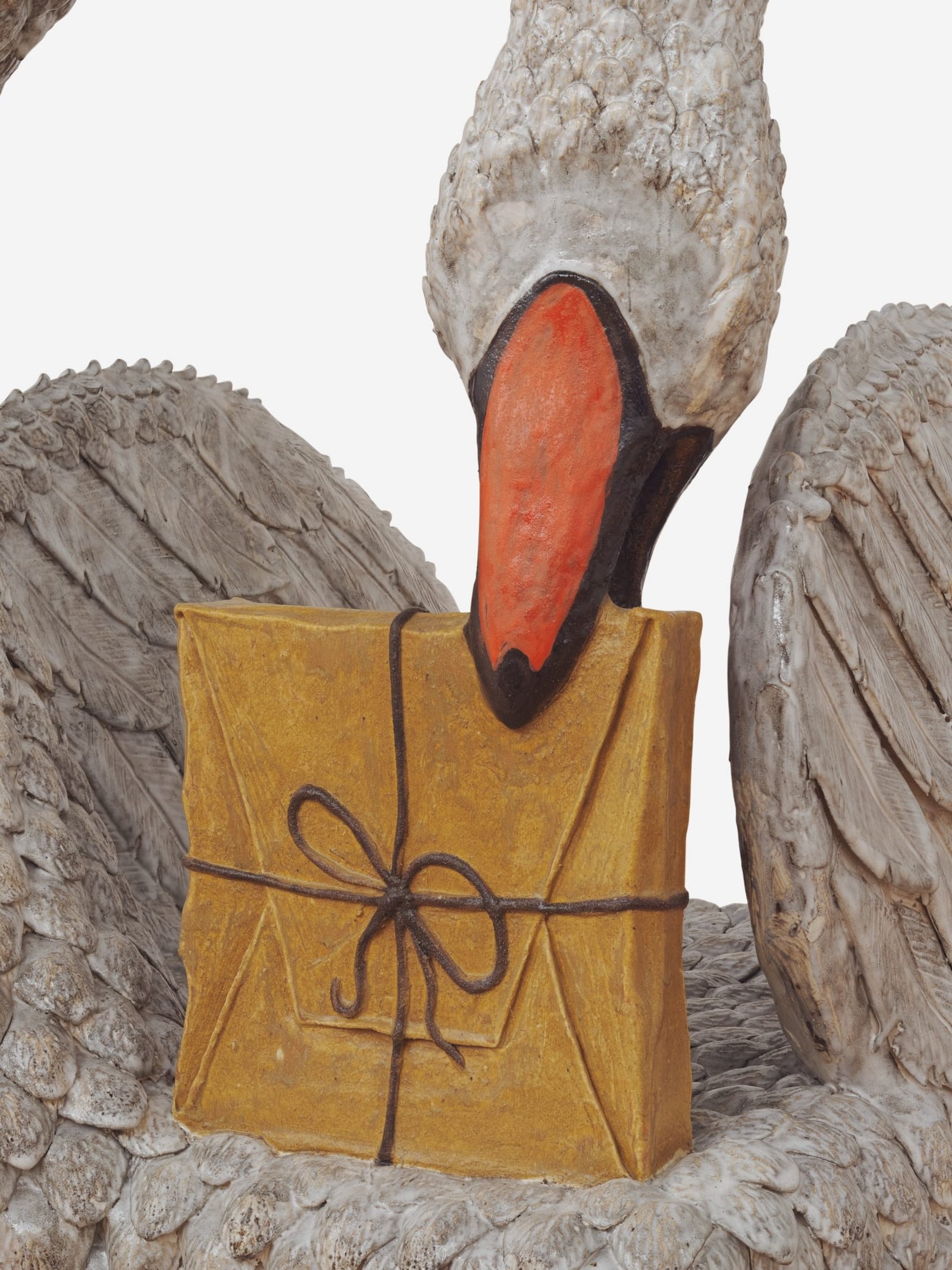 a detail of a ceramic chair sculpture by Stephanie Temma Heir shaped like a swan with a small painting wrapped like a gift embedded in its back 