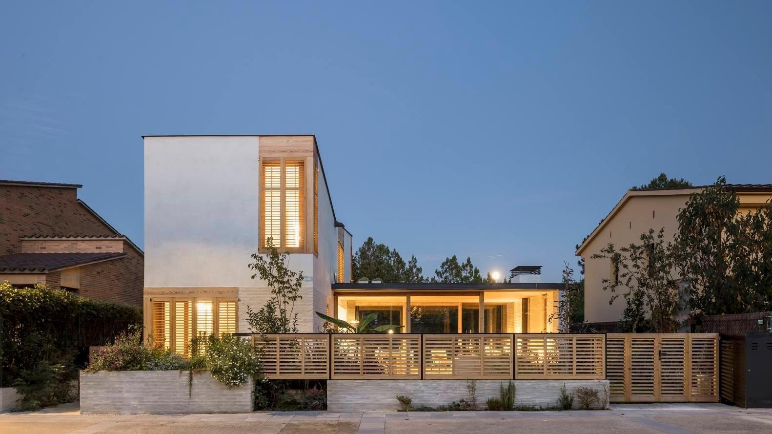 This Spanish family home is shaped by two contrasting volumes, a slender vertical block for privacy and a glass-lined entertaining area that opens fully to the garden.
