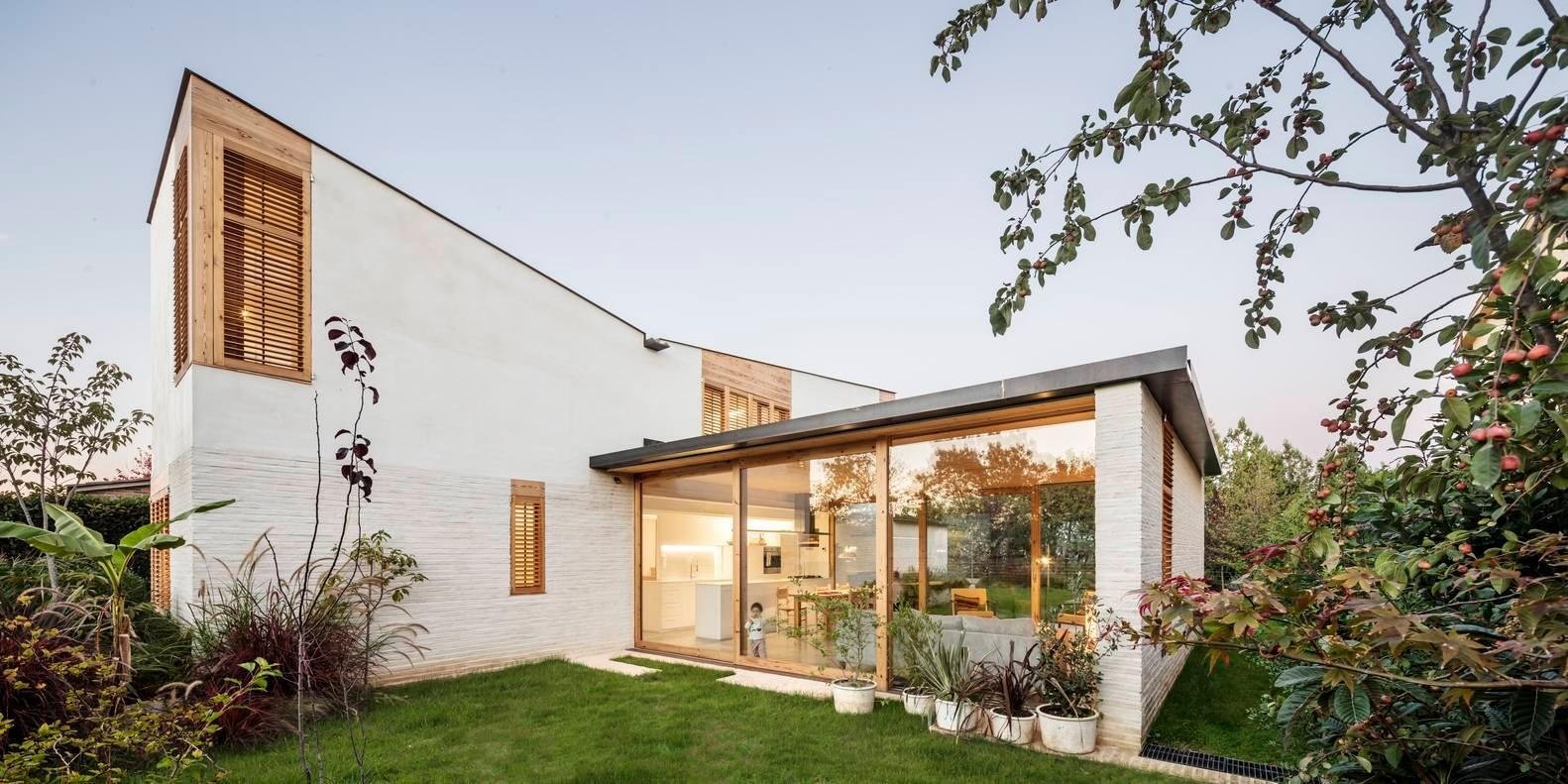 A transparent horizontal volume forms the heart of the home, with sliding glass walls opening to the garden on both sides.